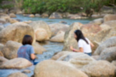 Defocus of two girls sitting in the lakeの写真素材