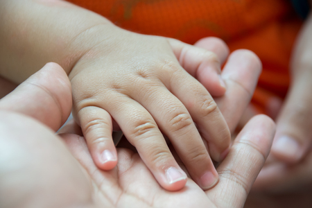 The mother's hand holding a baby's handの写真素材
