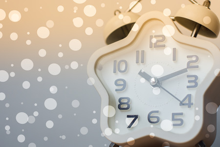 Closed up of modern white clock on background with bokeh and sun light