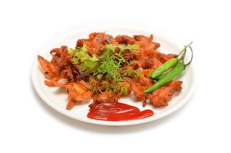 Onion pakodas and ketchup, dressed with green chilies isolated on white backgroundの写真素材