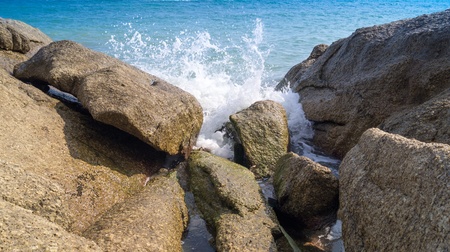 The waves break on the huge rocksの写真素材