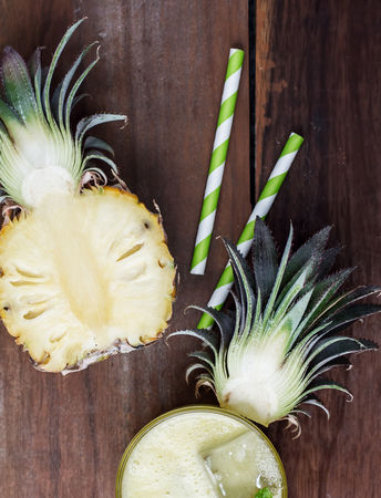 Healthy pineapple smoothie with fruit on rustic wooden backgroundの写真素材