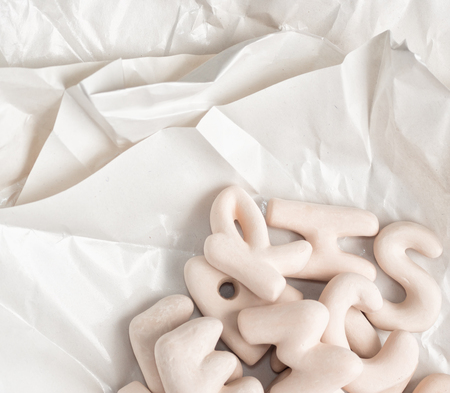 ceramic letters on layers of wax paper. Craft, art concept. Text spaceの写真素材