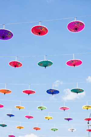 Thai multicolored umbrellas against blue sky. Traditions, festival background. Text spaceの写真素材
