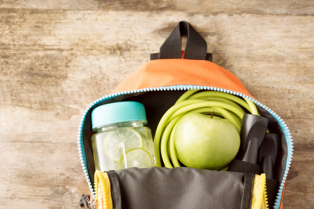 jumping rope, detox lime drink and green apple in backpack on wooden table. Sport, healthy lifestyle concept. Text spaceの写真素材