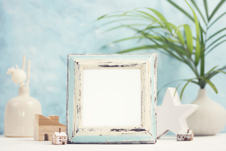 Bright tropical mock up with vintage white and blue photo frame; palm leaves in vase and home decor. Travel; summer concept. Text spaceの写真素材