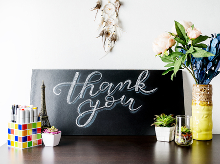 Creative White and blue Chalk Lettering Thank you on chalkboard on table with plants, flowers and art objects in home interior. Thanksgiving, holiday concept.の写真素材