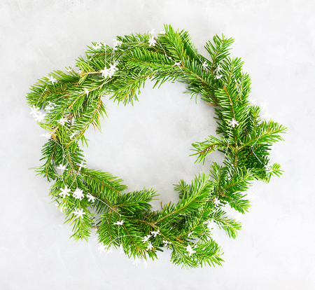 Top view flat lay green Christmas wreath on bright background. Traditional New year decoration concept. Space for letteringの写真素材