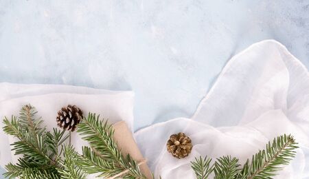 flat lay top view christmas tree branches with toys, fir-cones and gifts in craft paper on blue background. New year holiday concepr. Text spaceの写真素材