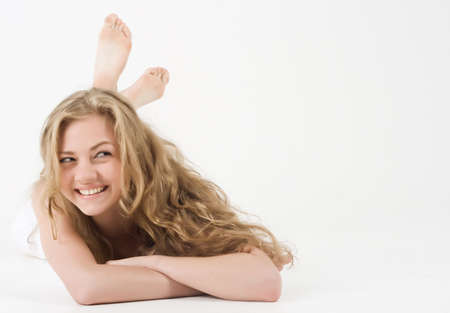Beautiful young woman lie on whiteの写真素材