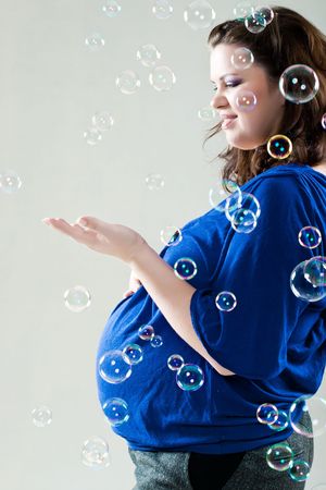 Beautiful pregnant woman with soap bubbleの写真素材