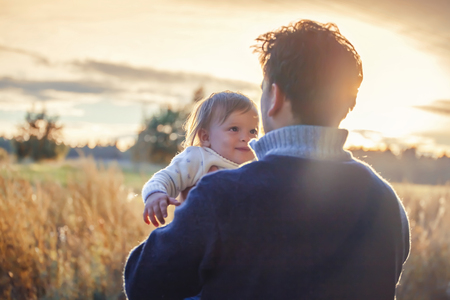 Father with little daughter at sunset