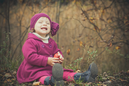 Little girl having fun in autumn parkの写真素材