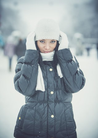 Beautiful young girl in snowy winter parkの写真素材