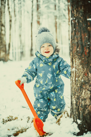 Funny little boy in snowy winter parkの写真素材