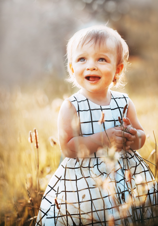 Shining happy little girl on summer meadow の写真素材
