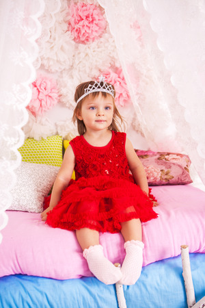 Cute little princess on pink bedの写真素材