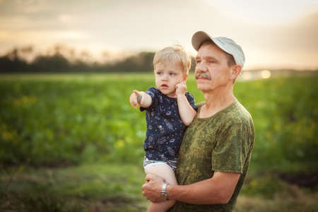Funny grangfather and grandson on summer day