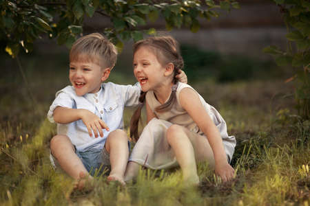 Funny twins boy and girl hugs and kissing in countryの写真素材