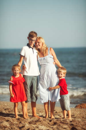 Happy family in red having fun at the seaの写真素材