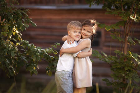 Funny twins boy and girl hugs and kissing in countryの写真素材