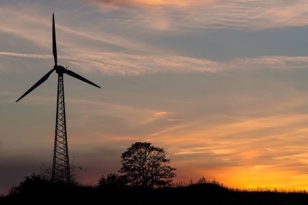 The wind power plant in a field at sunset の写真素材
