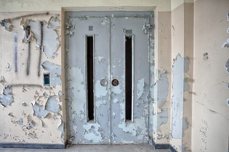 Door to the elevator in an abandoned buildingの写真素材