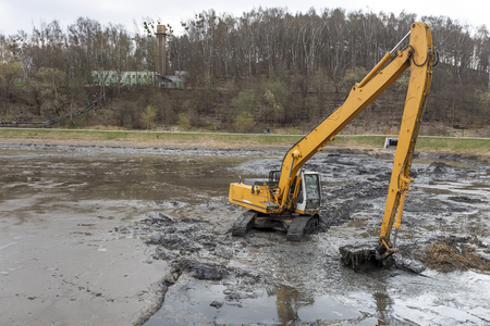 Excavator working at deepening the pondの写真素材