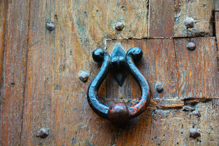 Round knocker on an old wooden entrance door