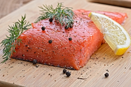 salmon fish with fresh herbs, pepper and lemonの写真素材