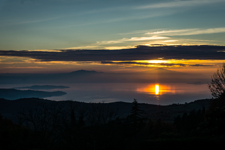 Sunset behind the mountains and reflection in the Lakeの写真素材