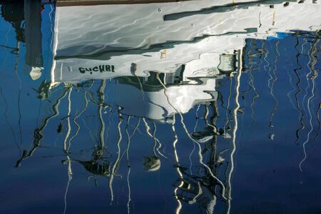 Reflection of boat in gentle rippled waterの写真素材