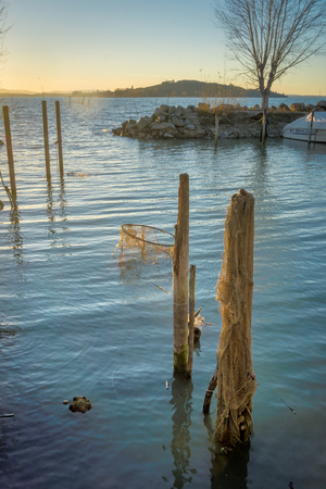 Jetty posts and fishing nets in the lakeの写真素材