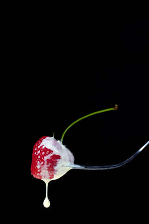 strawberry and cream on a forkの写真素材