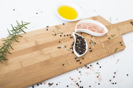 Himalayan rock salt and peppercorns, set against a white backgroundの写真素材