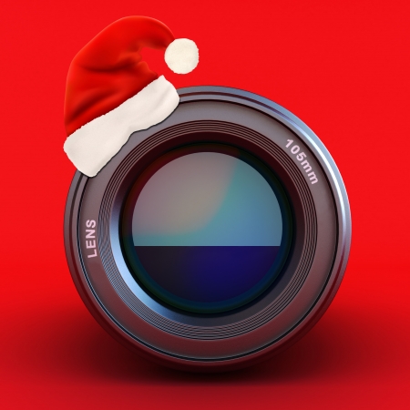 Camera lens with Santa hat on a red background の写真素材