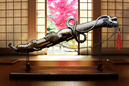 Ancient knife decoration on display with an orient themed depth of field background  の写真素材