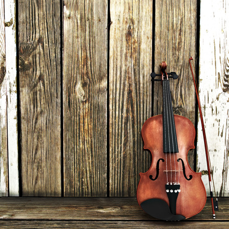 A Violin leaning on a wooden fence. Advertisement with room for text or copy spaceの写真素材