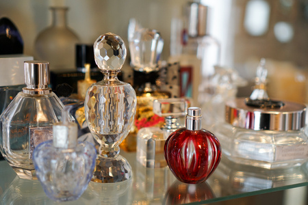 Colorful perfume glass bottles on shelf with various shapes and sizesの写真素材