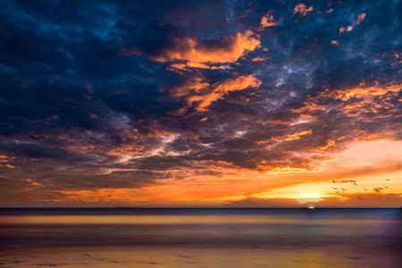 Colorful skies with clouds in the sky on the beach during sunset in Southern Thailandの写真素材