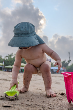 Baby playing on the beach. Little boy playing with sand and toys.の写真素材