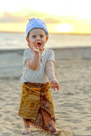 Cute little boy playing on the beach at sunset. Adorable baby having fun outdoors.の写真素材