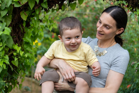 Portrait of a happy mother with her son in the garden.の写真素材