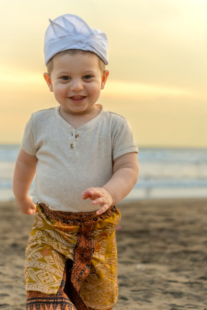 Cute baby boy walking on the beach at sunset. Happy childhood.の写真素材