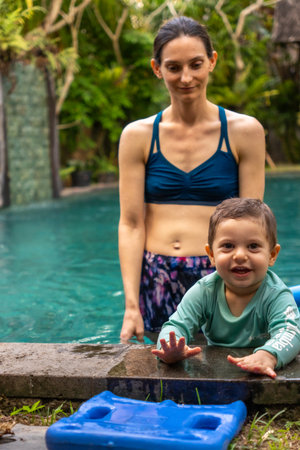 Mother and son playing in swimming pool at tropical resort in Bali, Indonesiaの写真素材