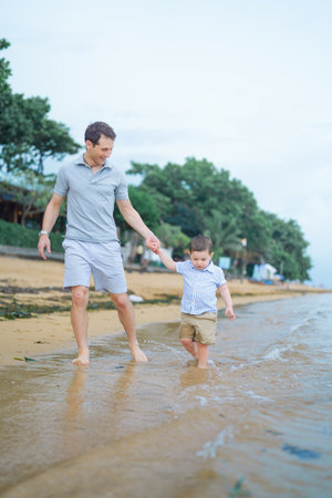 Father and son playing on the beach. Concept of friendly family.の写真素材