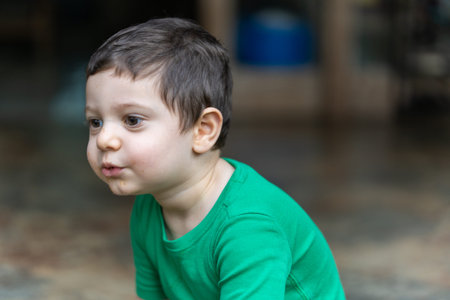 Portrait of a little boy in a green T-shirt.