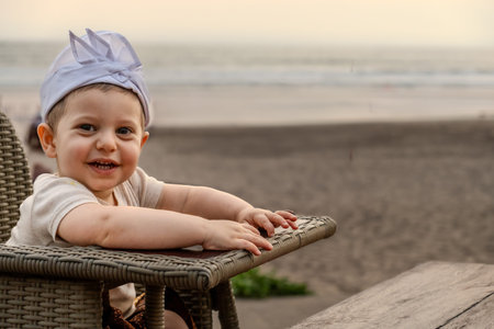 Portrait of a cute little baby boy on the beach at sunset