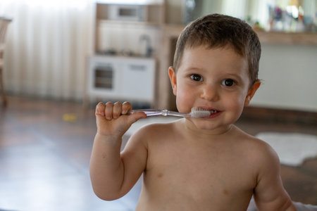 Cute little boy brushing his teeth with a toothbrush at home