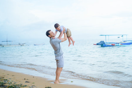 Father and son playing on the beach. Concept of friendly family.の写真素材